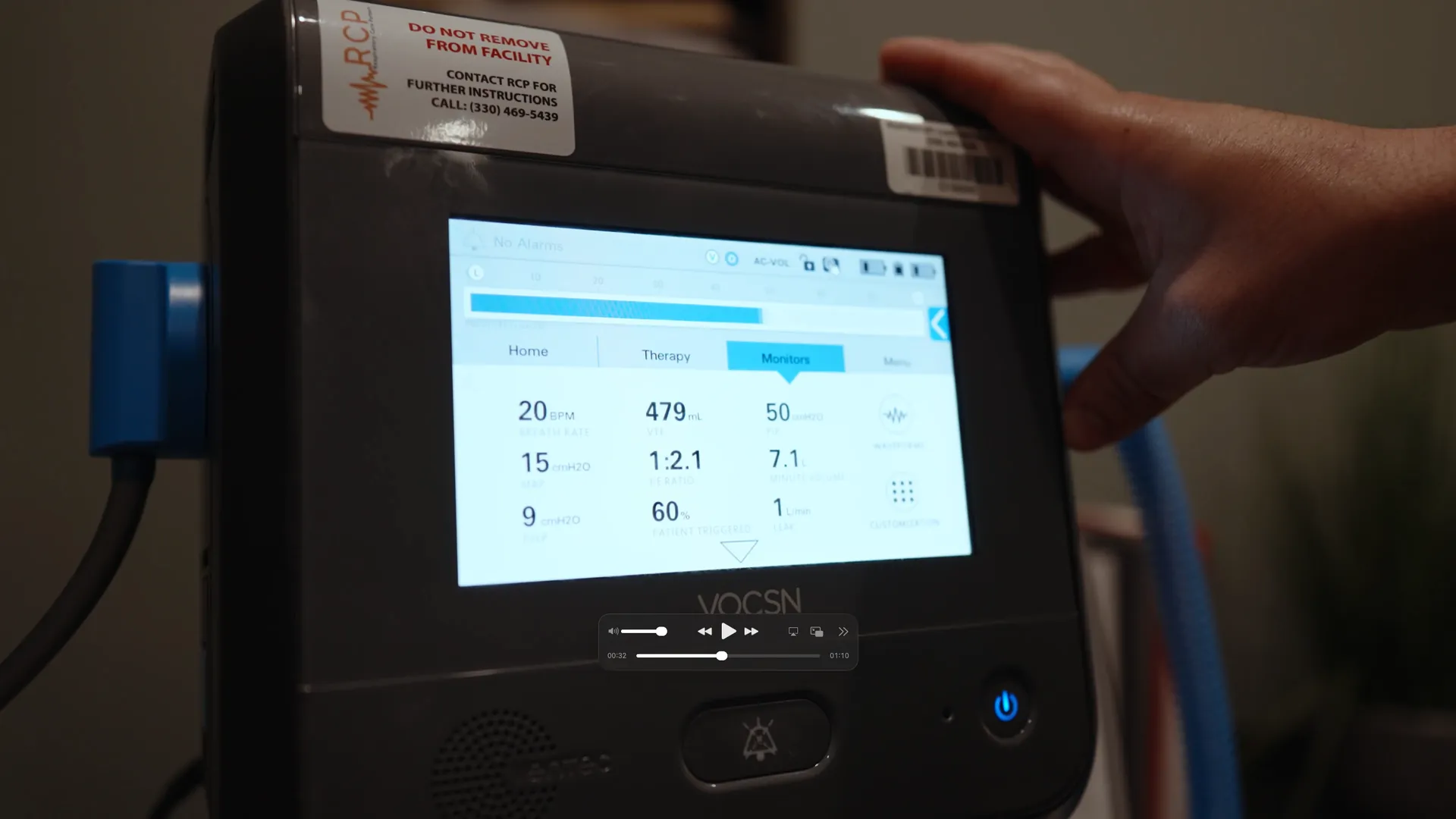 Close-up of a VOCSN ventilator monitor with a clinician operating it